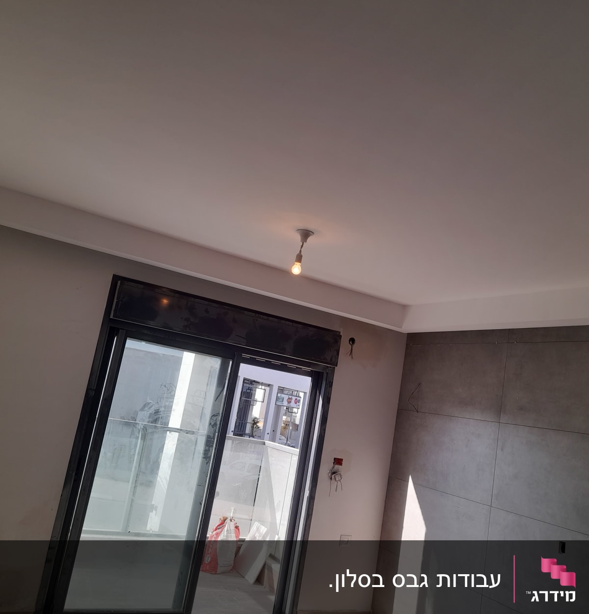 קיר גבס עם חיפוי חלק ליד חלון זכוכית